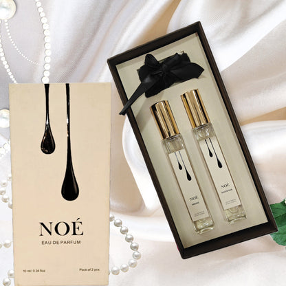 NOÉ Eau de Parfum gift set with two 10ml spray bottles on satin fabric with pearls and green leaves