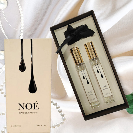 NOÉ Eau de Parfum gift set with two 10ml spray bottles on satin fabric with pearls and green leaves