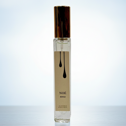 Perfume bottle labeled 'NOE' on a light blue background